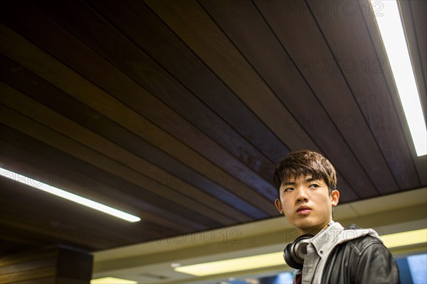 Asian man walking under wooden ceiling