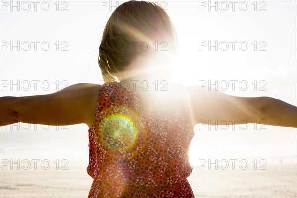 Caucasian girl standing with arms outstretched on beach