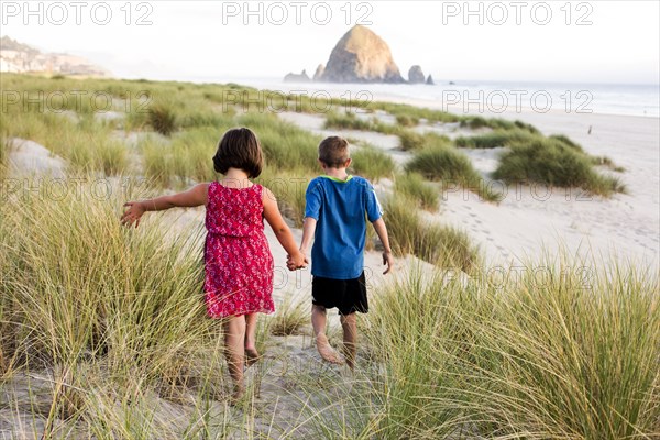 Caucasian children walking on beach