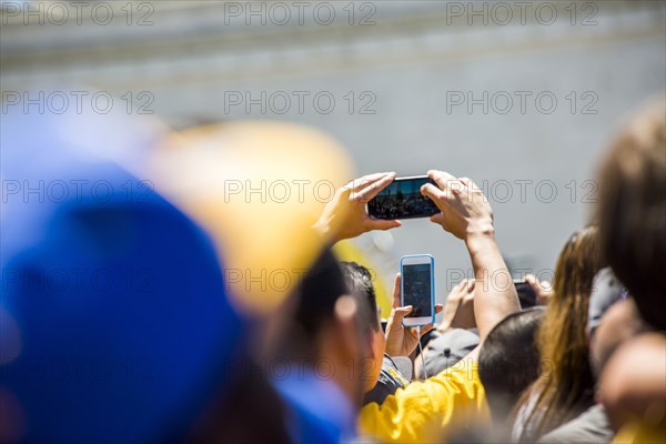 Crowd of fans photographing sporting event