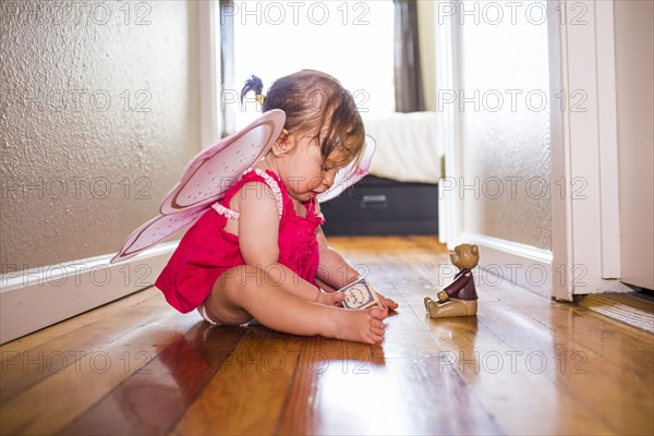 Caucasian baby girl playing in fairy wings