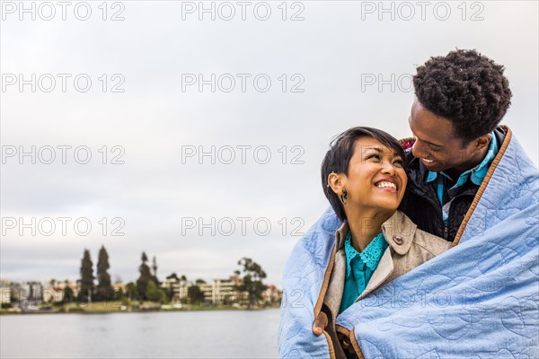Couple wrapped in blanket outdoors