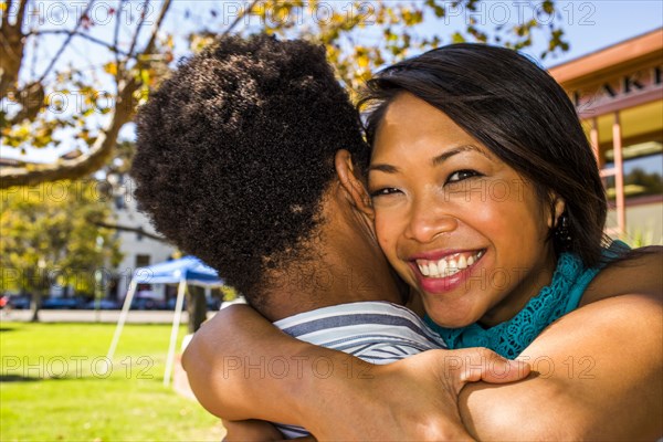 Smiling couple hugging in park