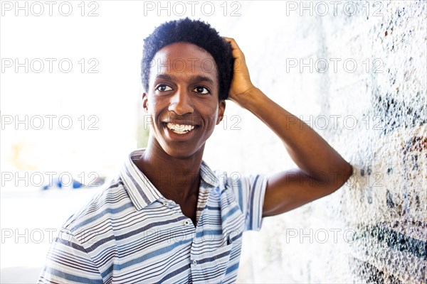 Man smiling by mural wall