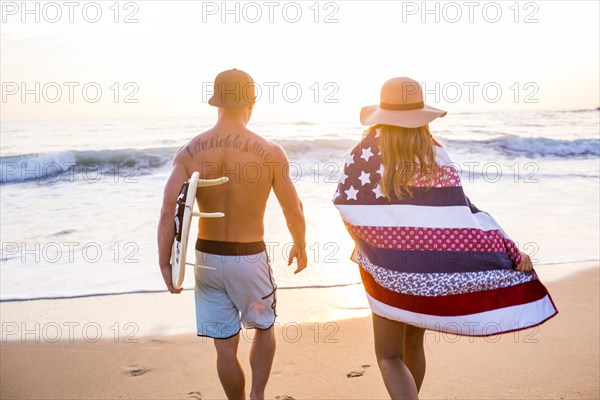 Caucasian couple walking on beach