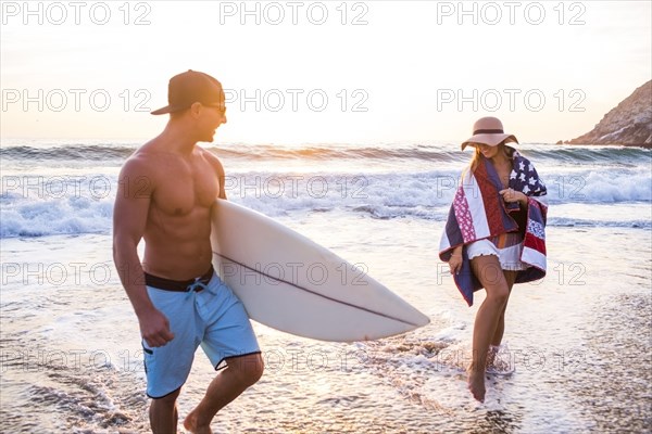 Caucasian couple walking on beach