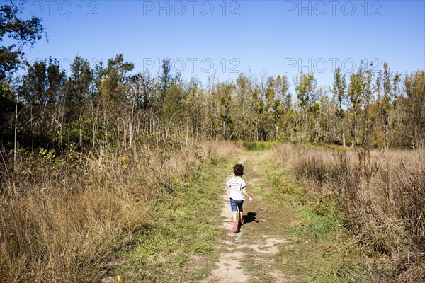 Mixed race boy walking on dirt path