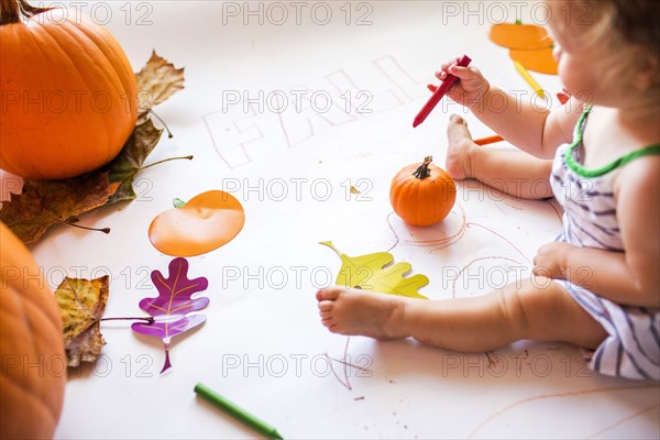 Caucasian baby girl drawing with crayon