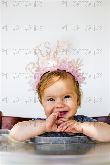 Caucasian baby girl wearing birthday crown