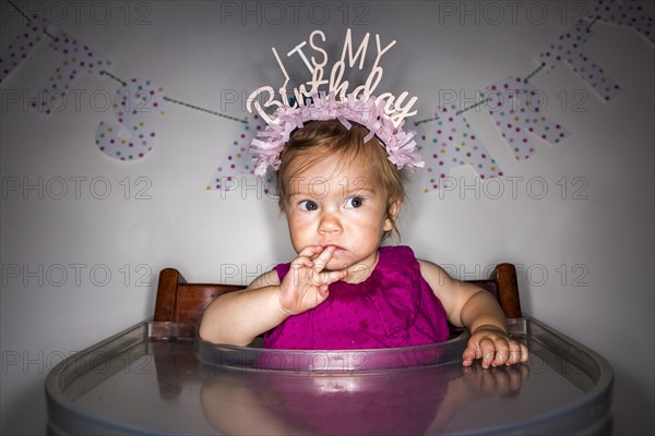 Caucasian baby girl wearing birthday crown