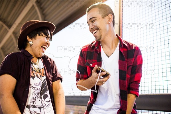 Couple sharing earphones to listen to music