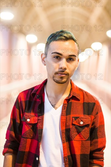 Serious Hispanic man wearing flannel shirt