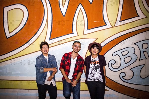 Friends smiling at mural outdoors