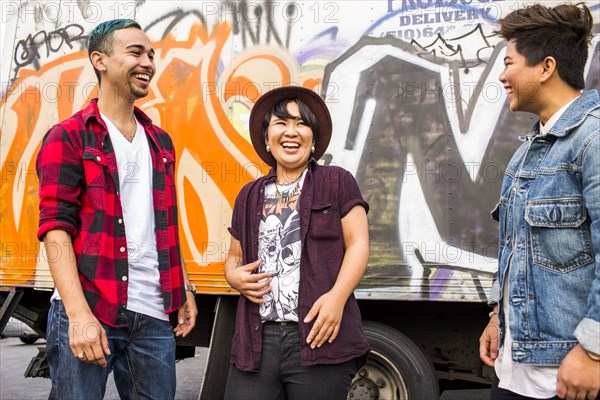 Friends laughing at graffiti wall