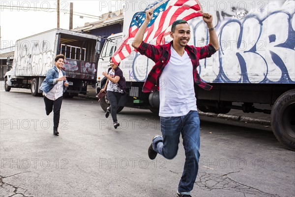 Friends waving American flag outdoors