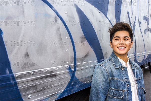 Asian woman smiling at graffiti wall