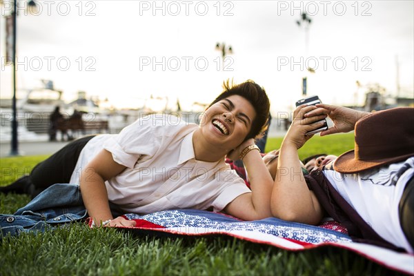 Asian friends laying in grass