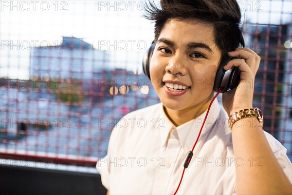 Asian woman listening to headphones outdoors