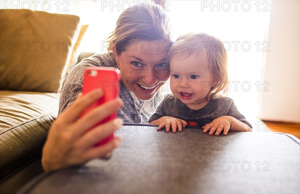 Caucasian mother and baby daughter taking selfie