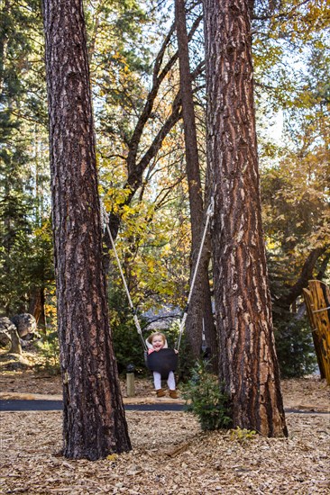 Caucasian baby girl playing in swing