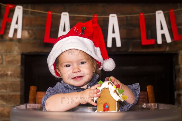 Caucasian boy holding gingerbread house