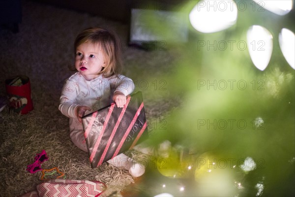 Caucasian girl opening Christmas gift