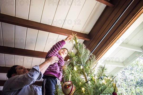 Father and son decorating Christmas tree