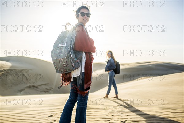 Mixed race women standing on sand dunes