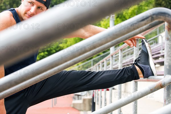 Caucasian man stretching leg at running track