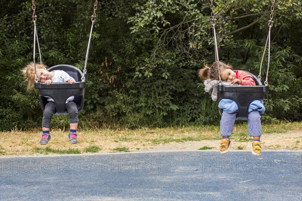 Girls sitting in still swings