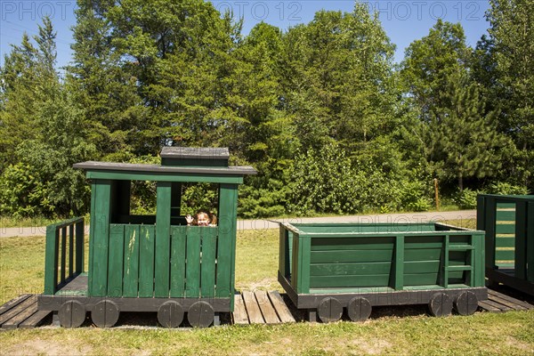 Caucasian baby girl waving on playground train