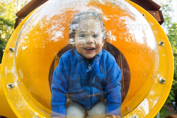 Caucasian baby girl smiling in playground bubble