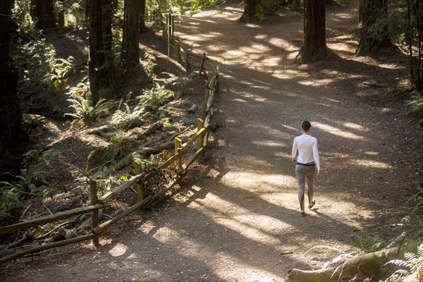 Woman walking on forest path