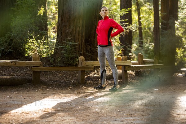 Pensive woman standing in forest