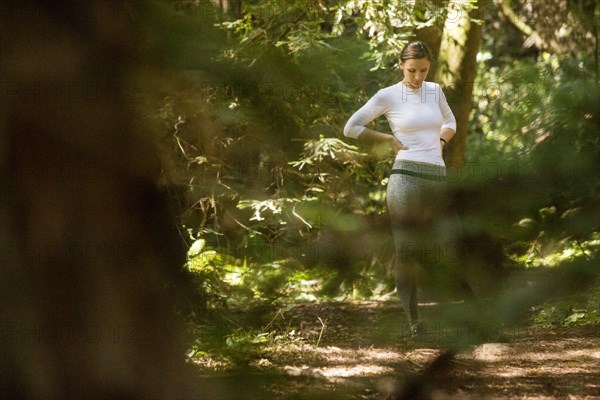 Pensive woman standing in forest