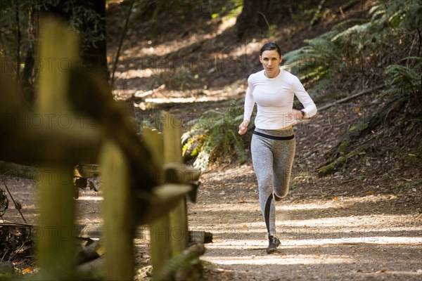 Woman running on forest path