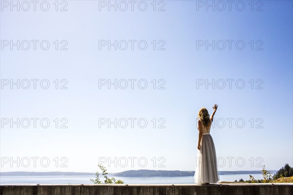 Caucasian bride waving near river