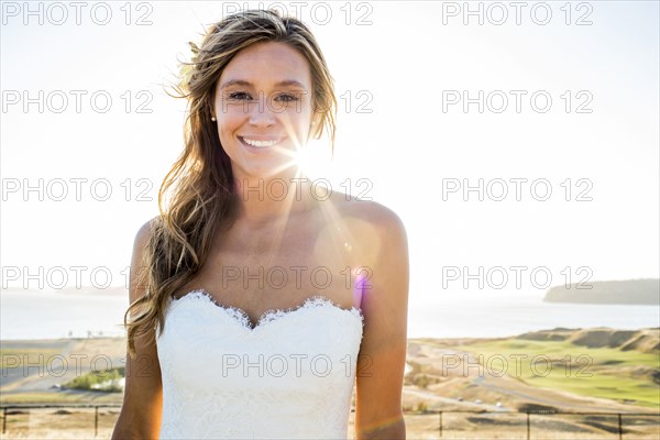 Caucasian bride smiling on sunny day