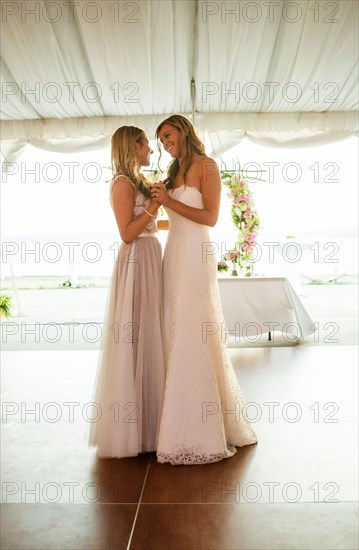 Caucasian brides dancing at wedding