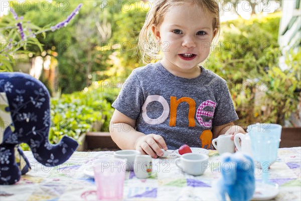 Caucasian girl playing with tea set