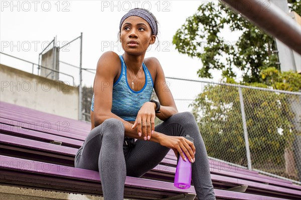 Black woman resting on bleachers