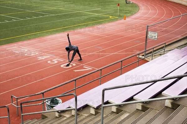 Black woman stretching on track