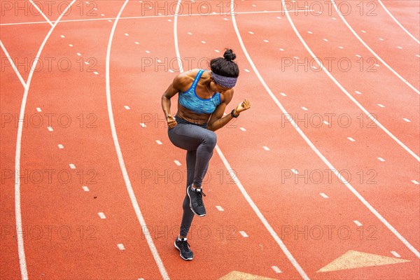 Happy Black athlete celebrating on track