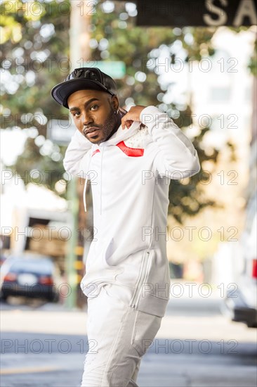 Black man adjusting hoody in city