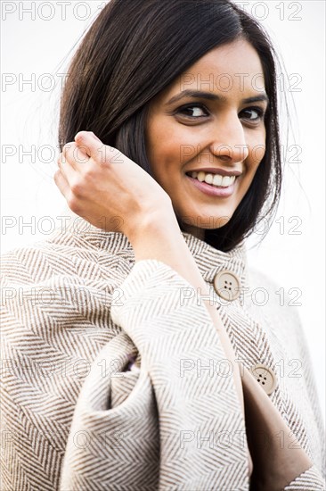 Portrait of smiling Indian woman wearing coat