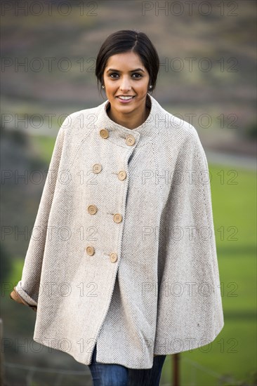 Portrait of smiling Indian woman wearing poncho