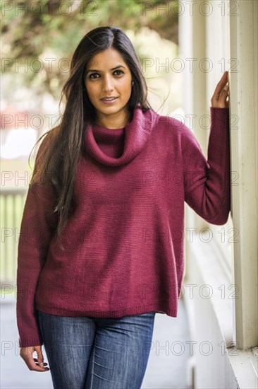 Serious Indian woman leaning on wall