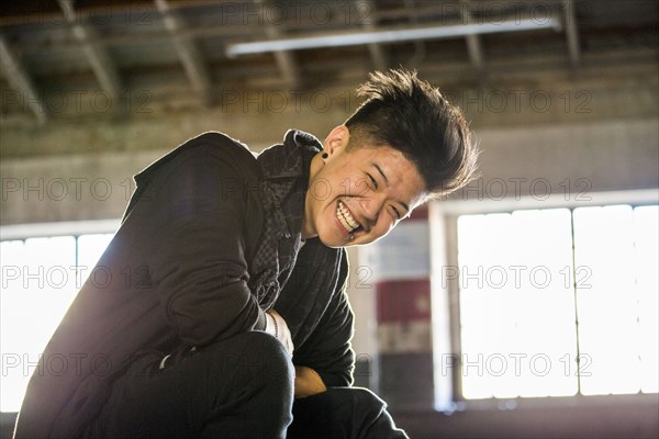 Portrait of laughing androgynous Asian man