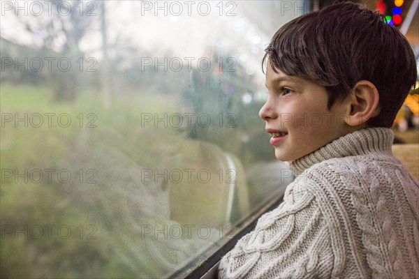 Mixed Race boy looking out train window