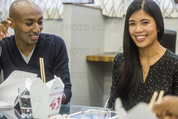 Smiling people in meeting with cartons of food